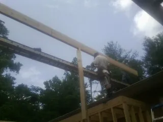 Carpenter setting a ridge beam over a new addition frame — Ice Dam Removal by Roofing Brothers in Stockertown