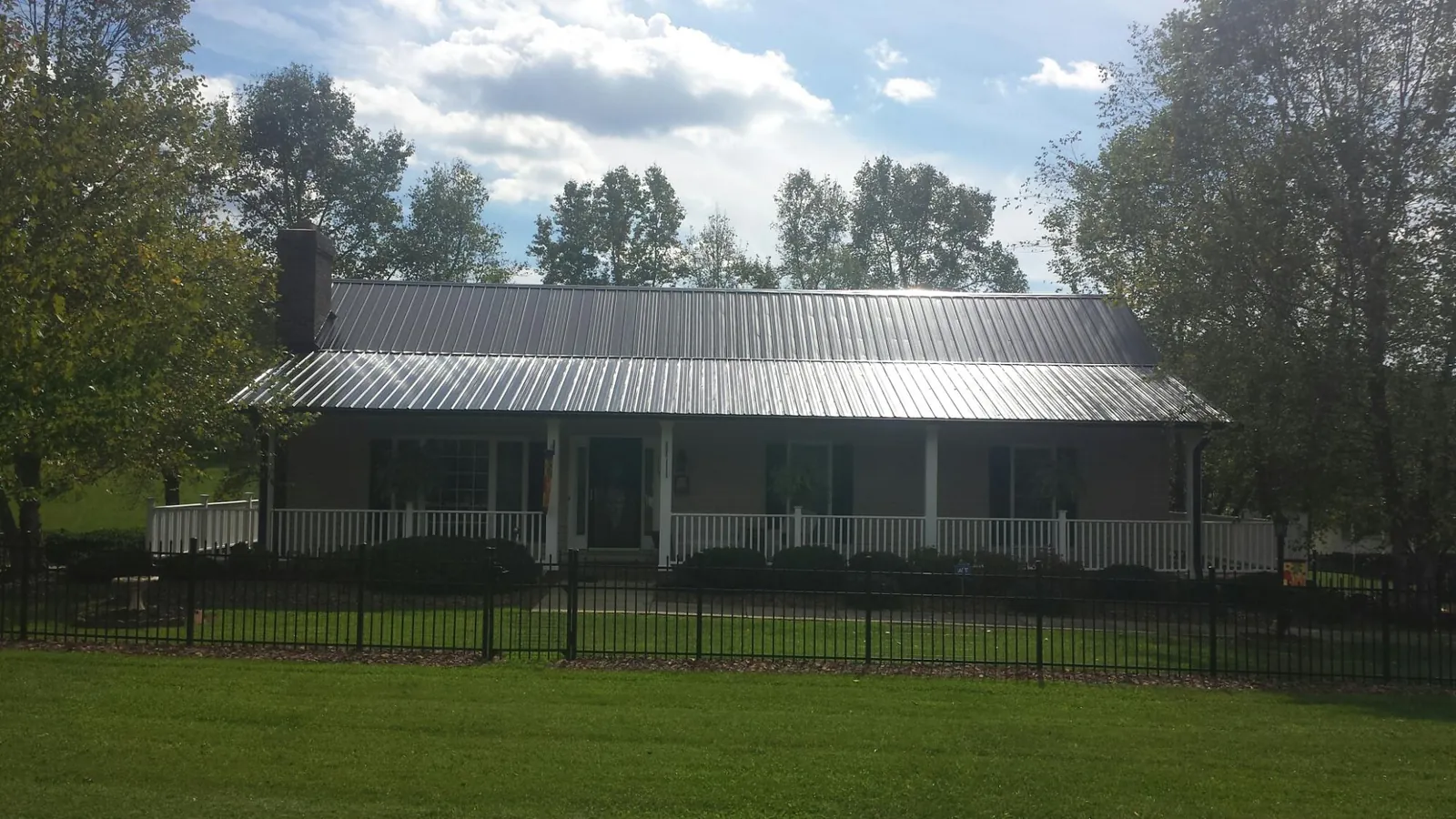 Gray metal roof on a brick ranch with a full width front porch — Gutter Guard Installation work by our crew in Stockertown