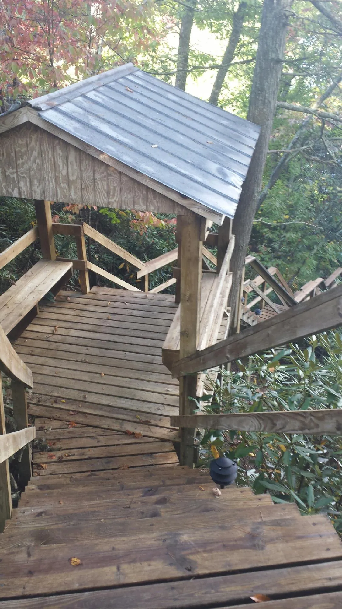 Metal roofed shelter over wooden steps on a wooded walkway — Skylight Repair & Installation work by our crew in Stockertown