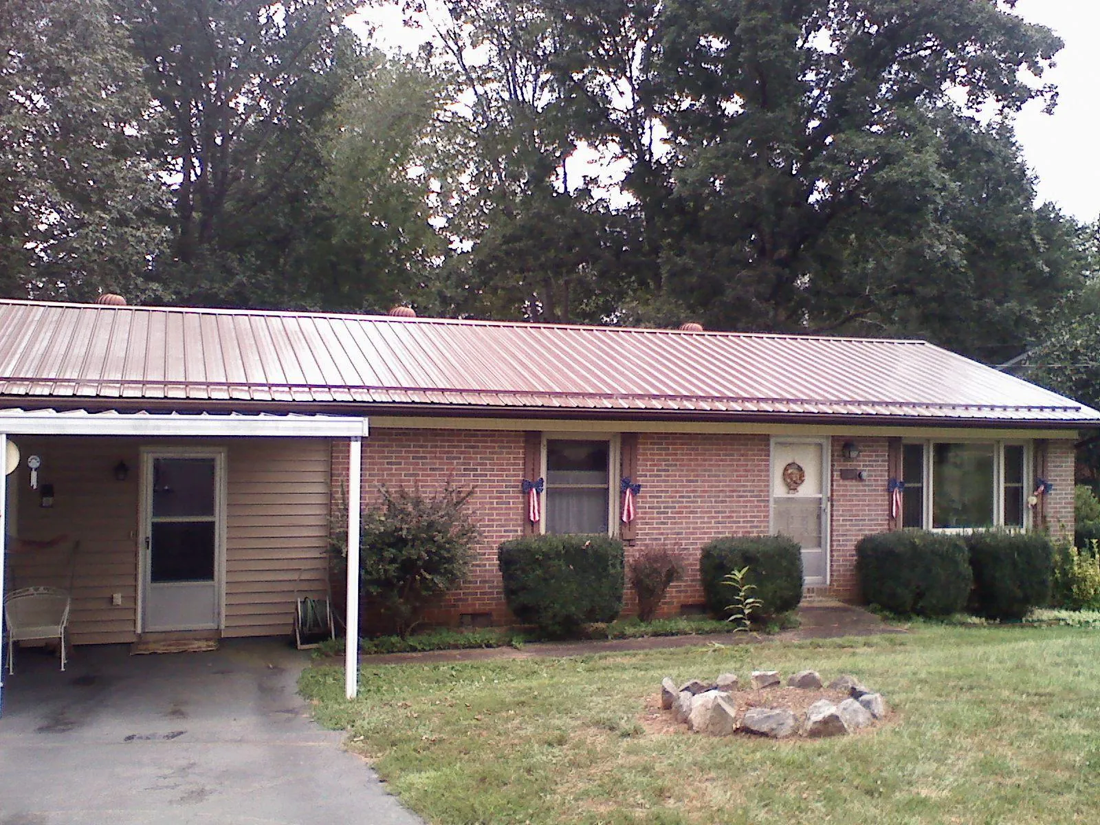 Bronze metal roof and carport on a brick ranch home — Roof Repair work by our crew in Stockertown